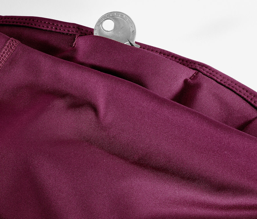 Detail einer 3/4-Sporthose in Beere mit Schlüssel in der Tasche.
