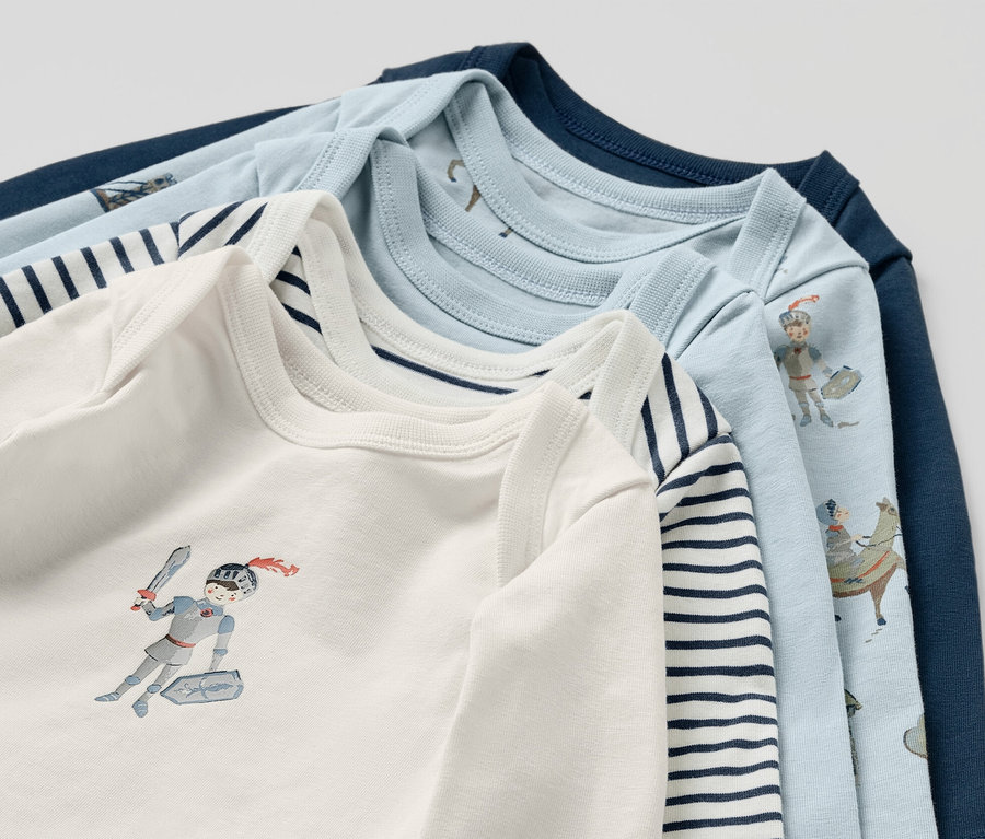 Detailaufnahme von fünf Baby-Bodys mit Ritter-Motiv.