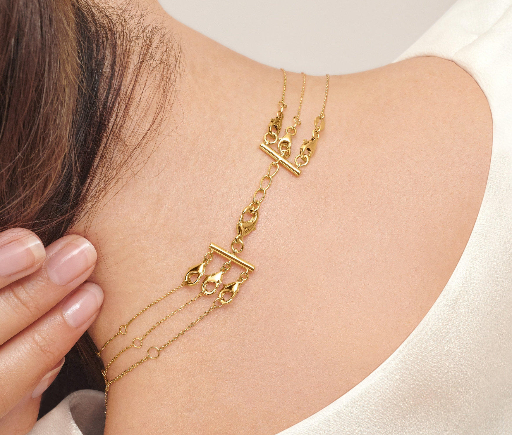 Frau trägt 2 Kettenverschlüsse für Layering.