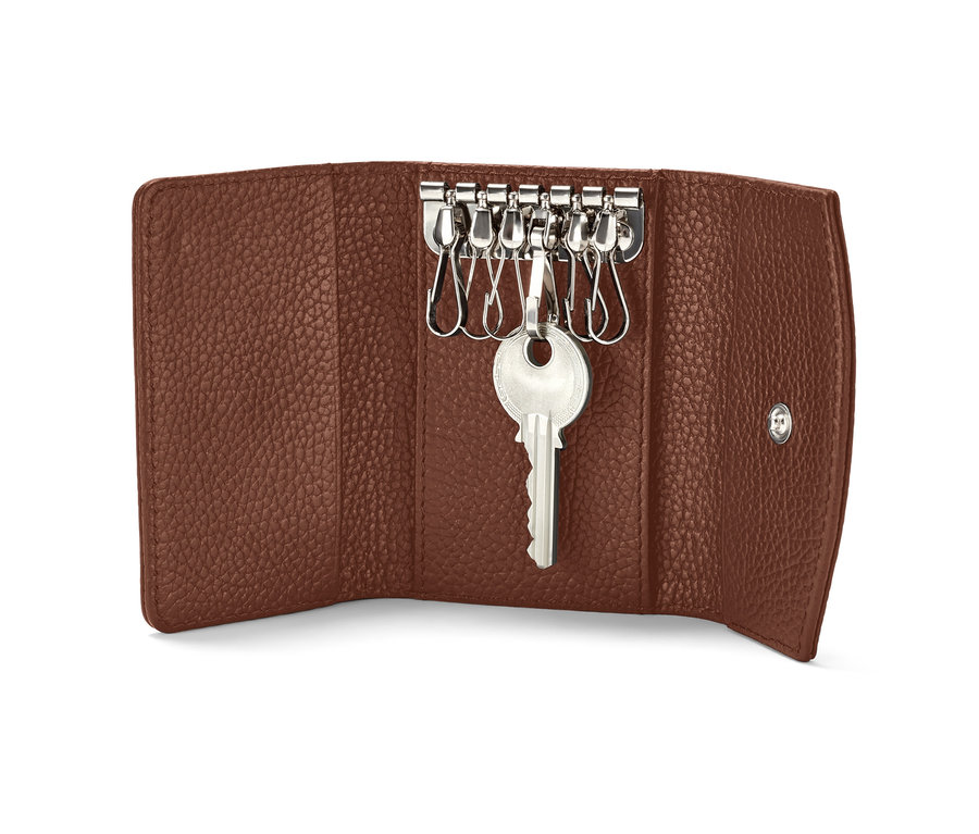 Offenes braunes Leder-Schlüsseletui mit einem Schlüssel, der an einem Metallhaken hängt.