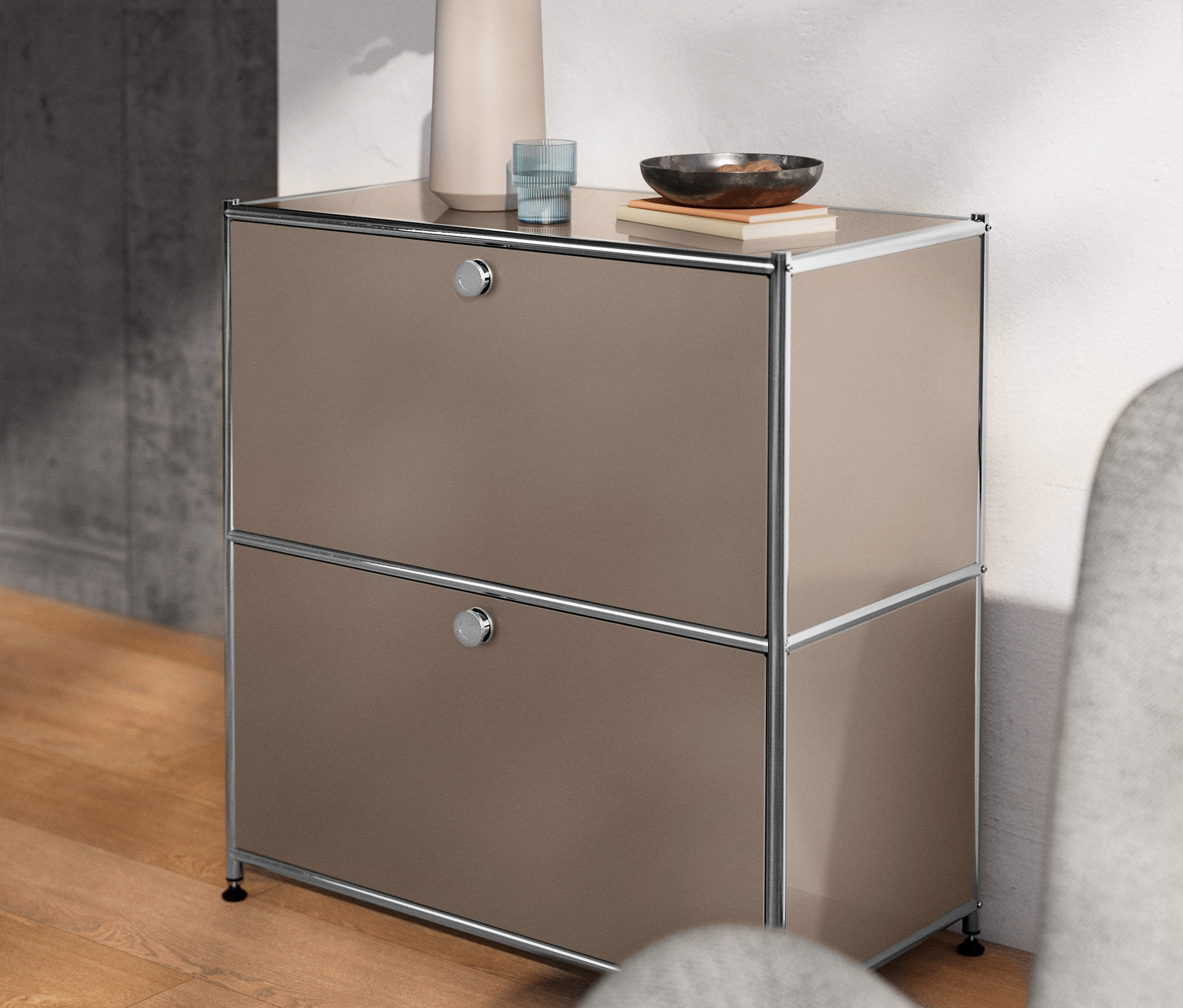 Niedriges Sideboard Metall »CN3« mit Klappenfächern. Oben Vase, Glas und Schale.