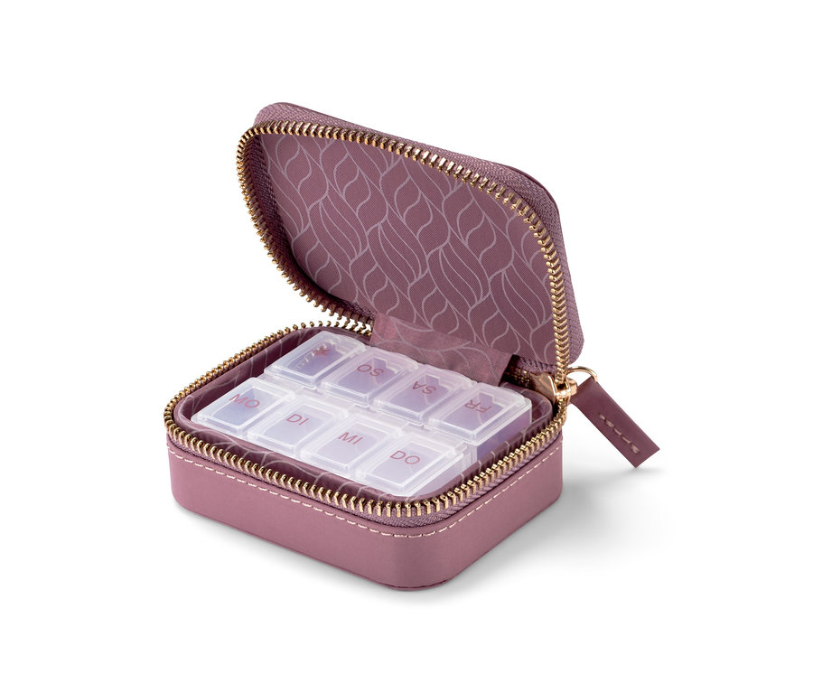 Geöffnete lila Pillendose mit transparenten Fächern, die mit Wochentagen beschriftet sind.