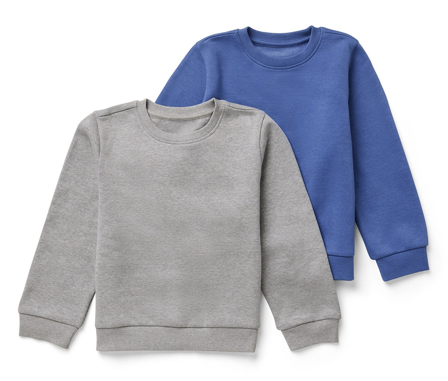Zwei Kinder-Sweatshirts mit angerauter Innenseite, eins grau und eins blau, liegen übereinander.