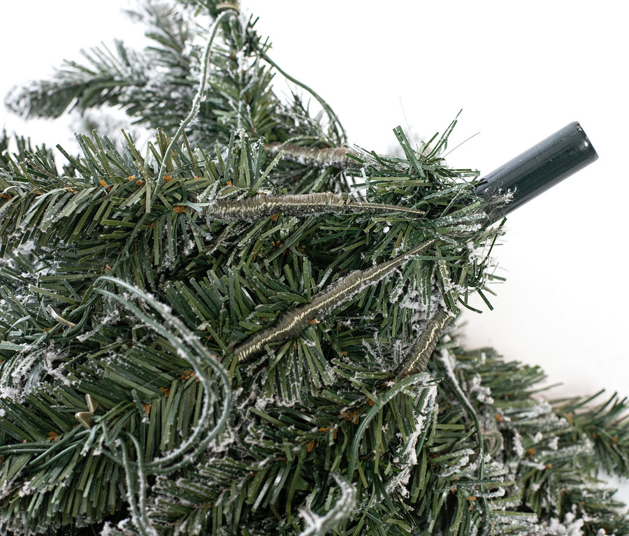 Nahaufnahme eines schneebedeckten Evergreen LED-Weihnachtsbaums mit Jutetopf.