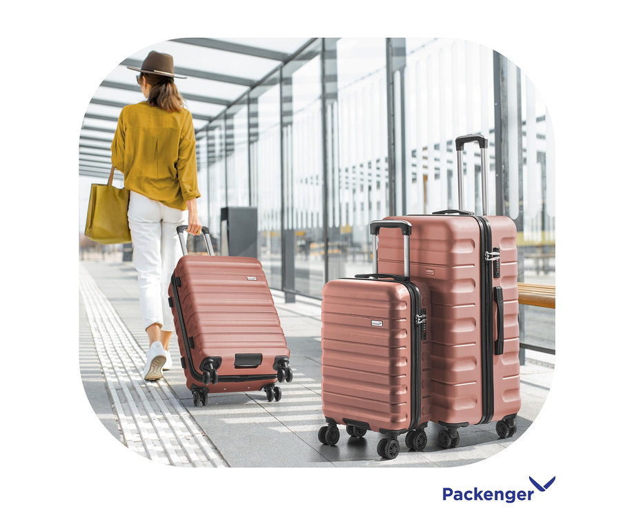 Frau zieht mauvefarbenen Packenger Jörn Rollenkoffer auf dem Flughafen. Zwei weitere Koffer stehen daneben.
