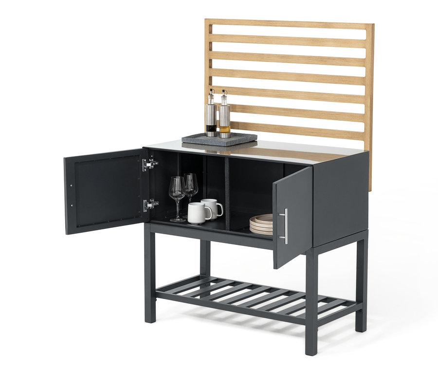 Graues Outdoor-Küchenmodul mit Lamellen-Wand. Zwei offene Türen, im Inneren Gläser, Tassen und Teller.