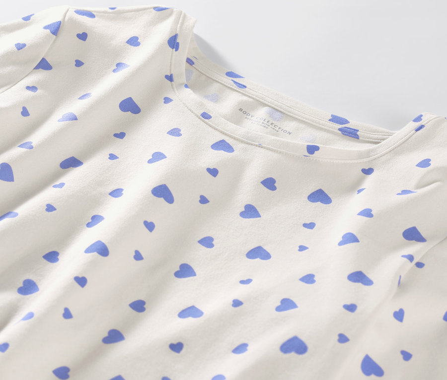 Detailansicht eines weißen Pyjamas mit hellblauen Herzen.