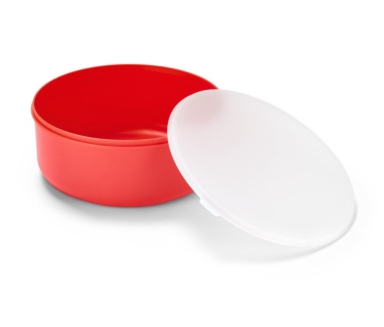 Eine rote Salatschüssel mit einem weißen Deckel liegt daneben.