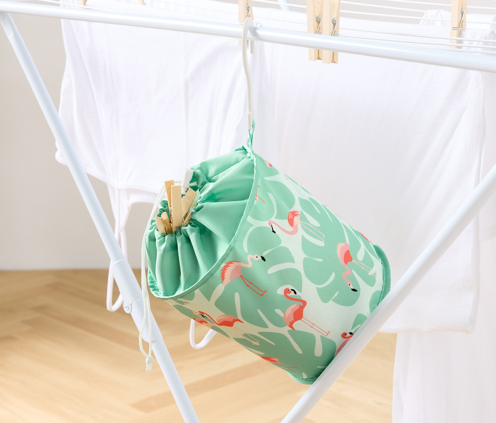 Ein Klammerbeutel hängt an einem Wäscheständer mit Wäsche.