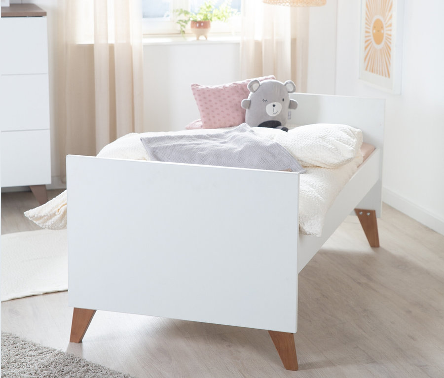 Ein weißes roba »Ole« Kombi-Kinderbett, 70 x 140 cm, mit Kissen und Teddybär.