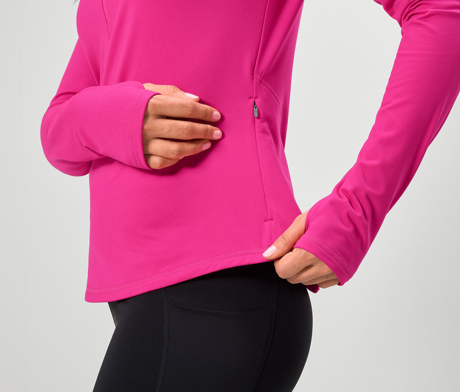 Frau trägt ein pinkfarbenes Langarmshirt und schwarze Leggings.