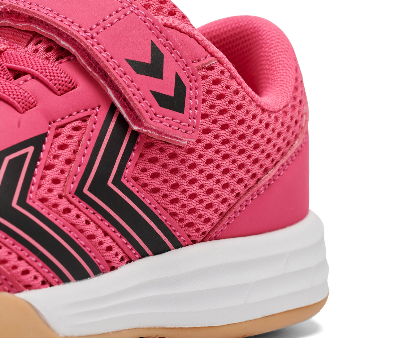 Detailaufnahme eines rosa HUMMEL Multiplay Flex VC JR Schuhs mit schwarzen Streifen und weißer Sohle.
