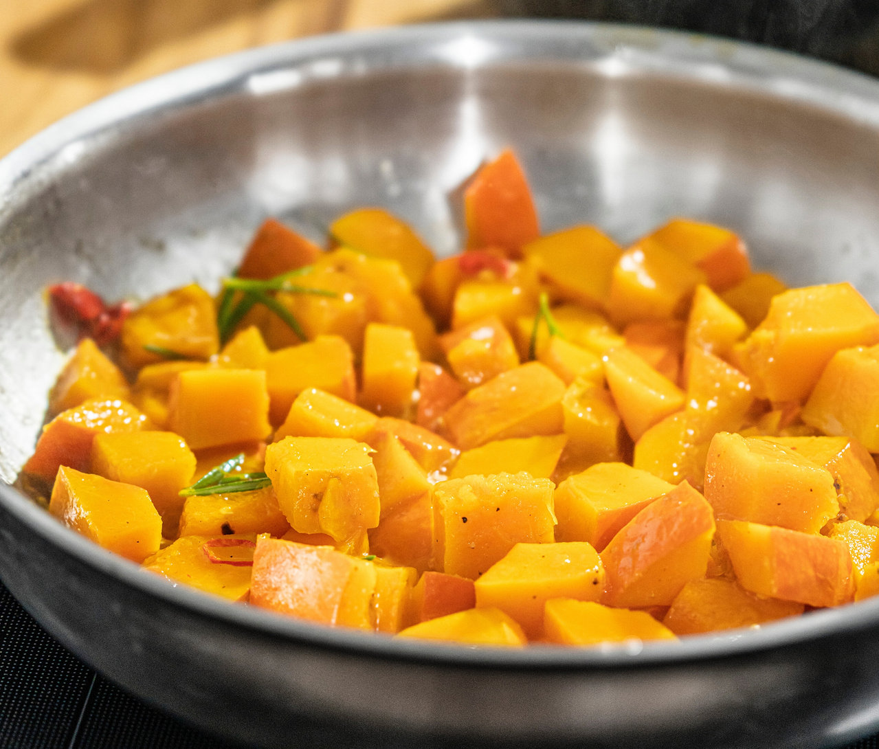 Nahaufnahme von gewürfeltem Kürbis in einer Edelstahlpfanne von Zwilling PRO (ca. 20, 24 und 28 cm).