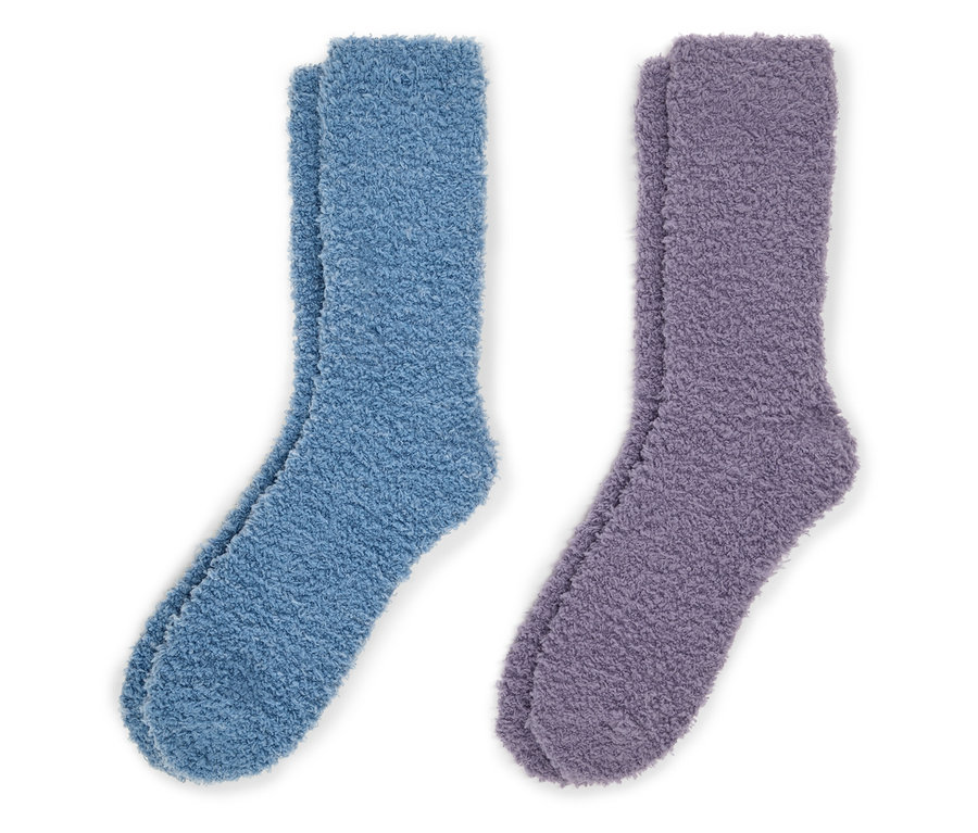 Zwei Paar flauschige Socken, ein Paar blau und ein Paar lila, liegen auf einem weißen Hintergrund.