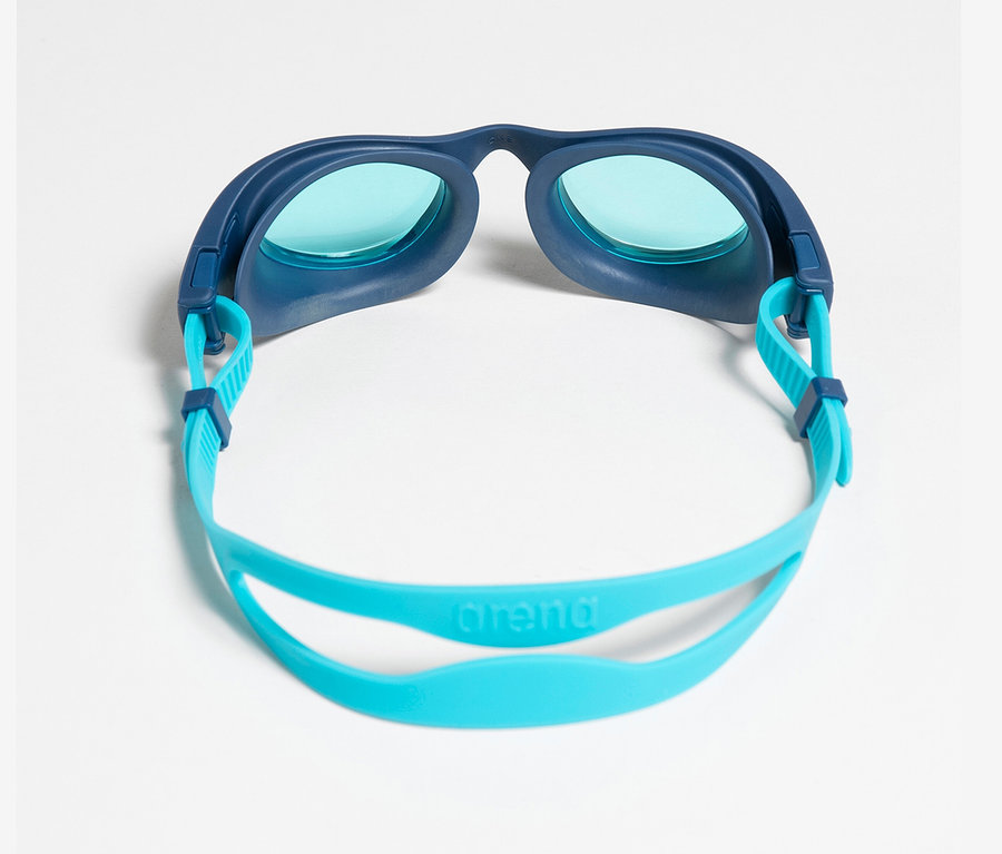 Eine blaue Kinder-Schwimmbrille mit blauen Gläsern und hellblauem Band liegt auf einem weißen Hintergrund. Zu sehen ist die arena Kinder-Schwimmbrille The One JR.