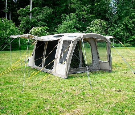 Ein beiges Tambu 4-Personen-Familien-Luftzelt steht auf einer grünen Wiese.