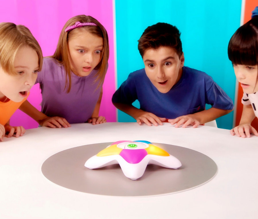 Vier Kinder schauen auf das Spiel Echt jetzt?! Junior auf dem Tisch.