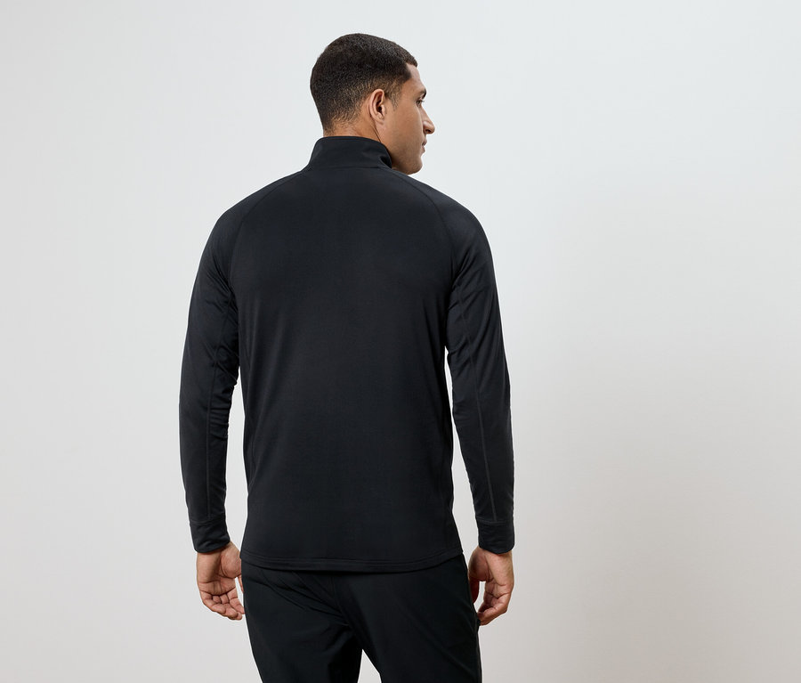 Mann trägt ein schwarzes Langarmshirt und eine Hose, von hinten gesehen.