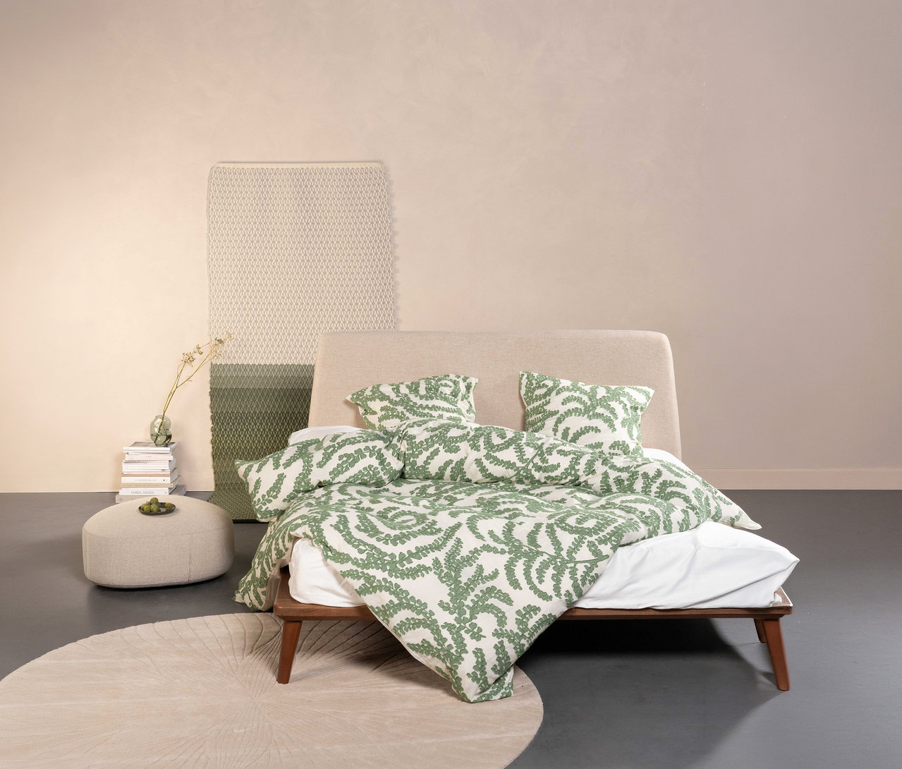 Schlafzimmer mit Bettwäsche »Eleria« von Essenza mit grünem Blattmuster, Normal- oder Übergröße, auf einem Bett mit beigem Kopfteil.