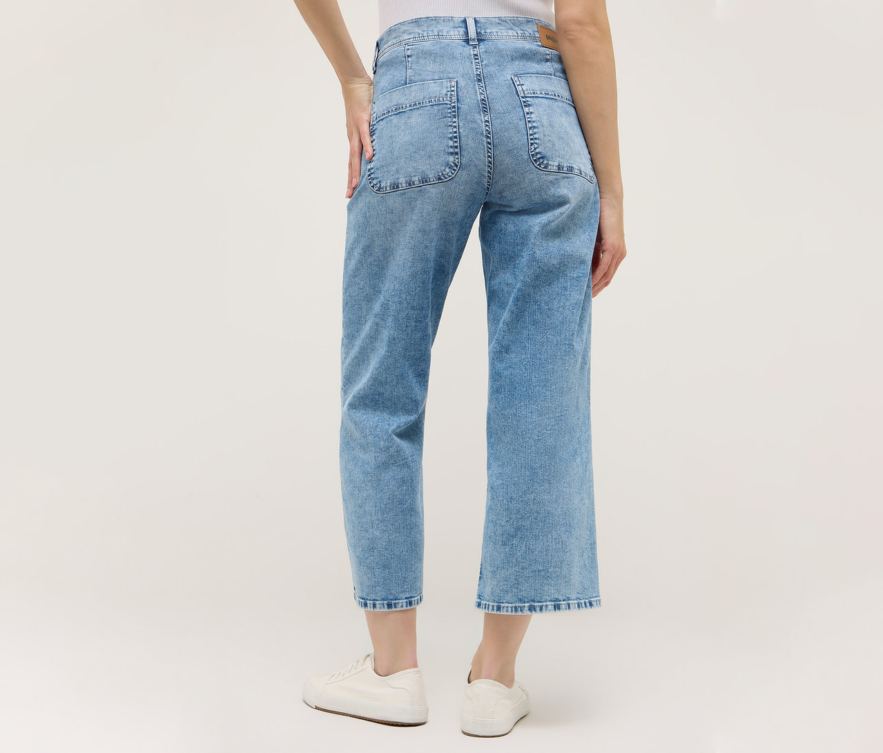 Rückansicht einer Frau mit hellblauer Angels Denim »Linn Smart« Culotte und weißen Schuhen.