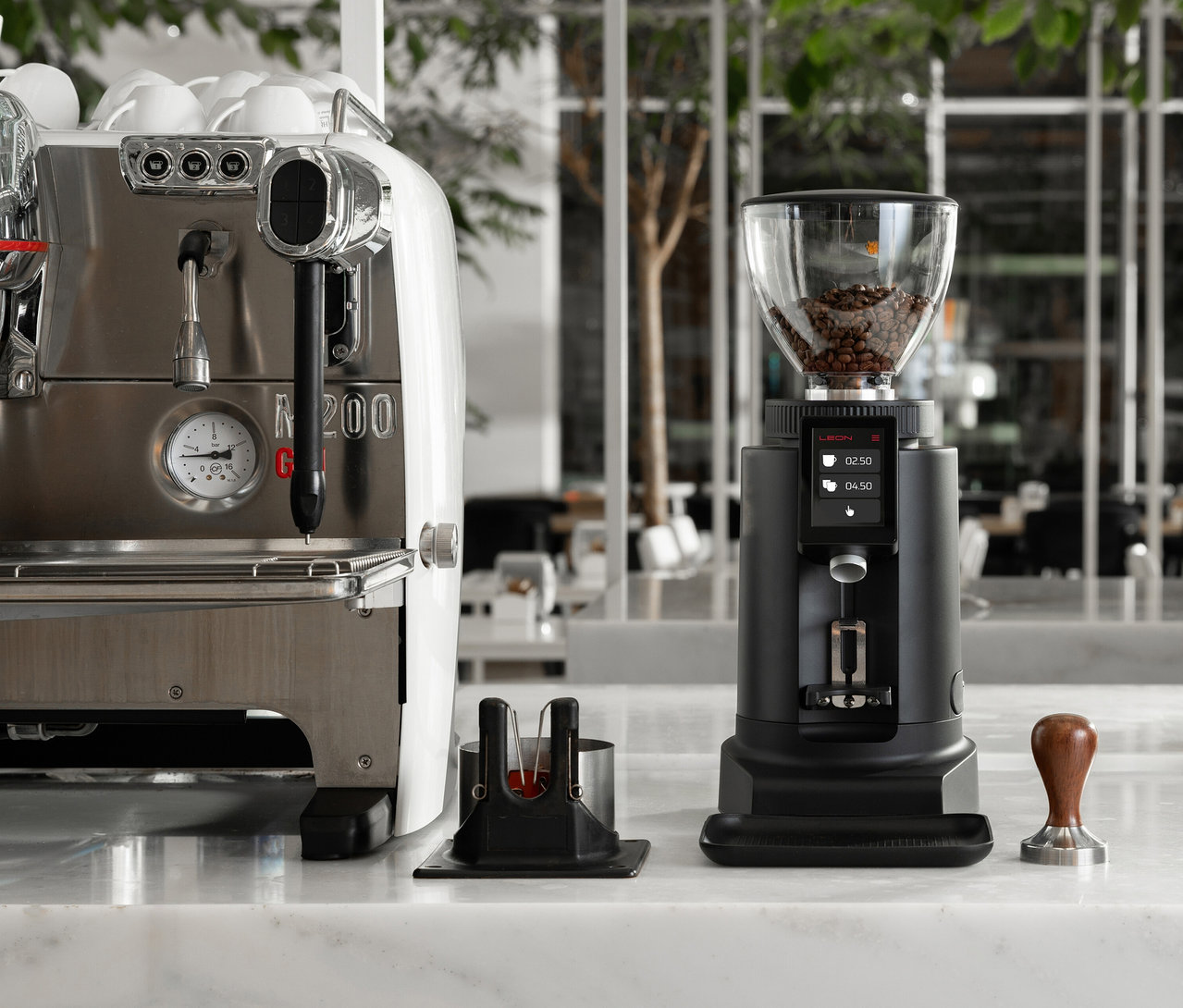 Eine Kaffeemühle und eine Espressomaschine stehen auf einer Marmoroberfläche.