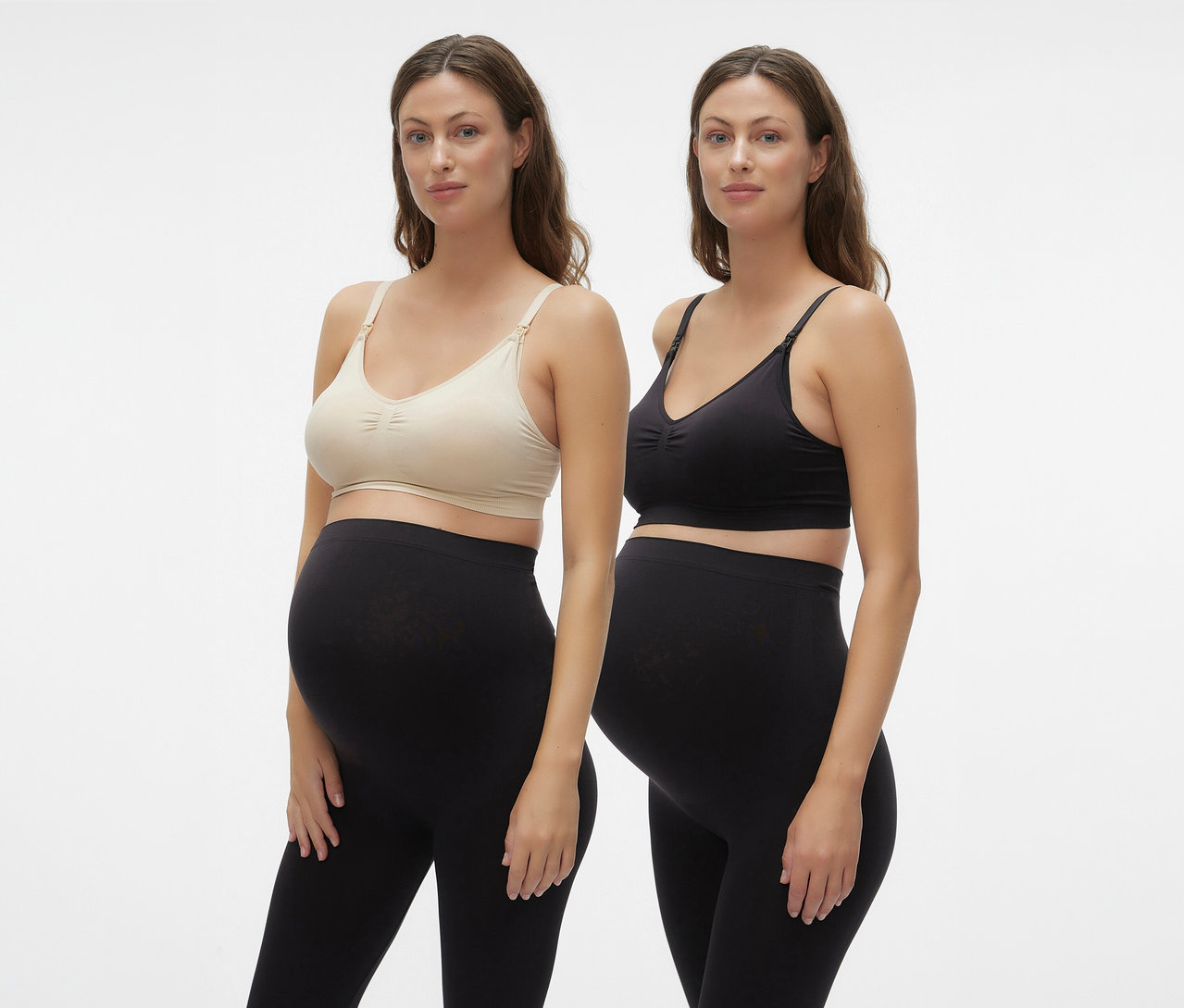 Zwei schwangere Frauen tragen MAMALICIOUS MLILJA FEED ME BRA 2-P NOOS und schwarze Leggings vor einem weißen Hintergrund.