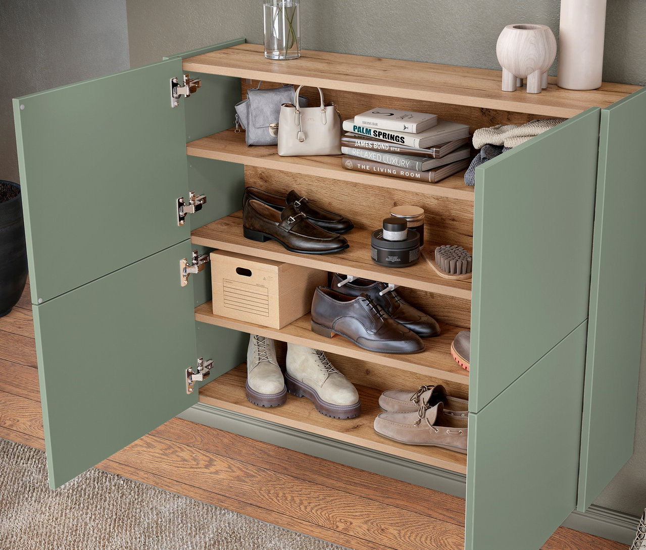 Offener Schuhschrank mit vier Regalen, gefüllt mit Schuhen, Taschen und Büchern.