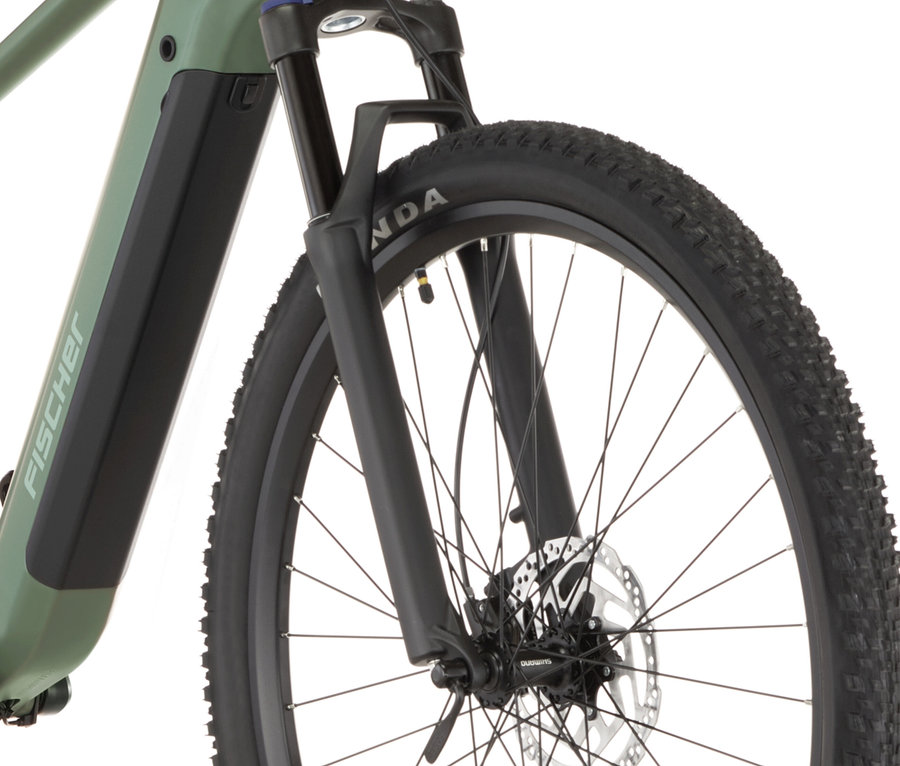 Nahaufnahme des FISCHER MTB E-Bike MONTIS MOVE 01 474 D mit Vorderreifen, Federgabel und Rahmen in Grün.