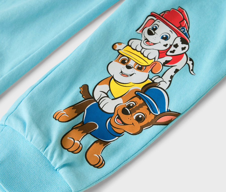 Nahaufnahme eines hellblauen Hosenbeins mit den Paw Patrol-Charakteren Marshall, Rubble und Chase.