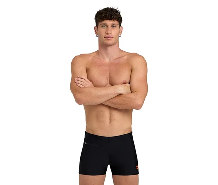 Mann mit verschränkten Armen trägt schwarze arena Herren-Badeshorts Zip.