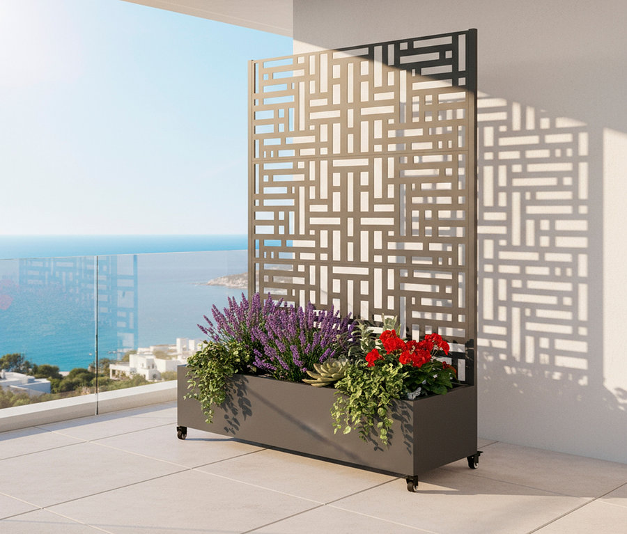 Blumenkasten mit Pflanzen und einem dekorativen Sichtschutz auf einer Terrasse mit Meerblick.