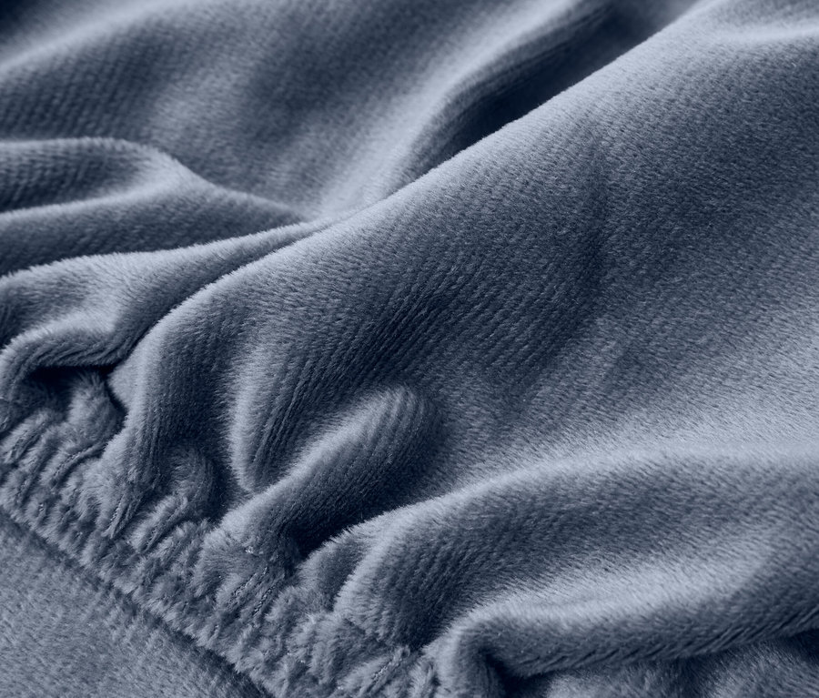 Nahaufnahme eines blaugrauen Plüschstoffs mit weichen Falten und einem elastischen Rand.