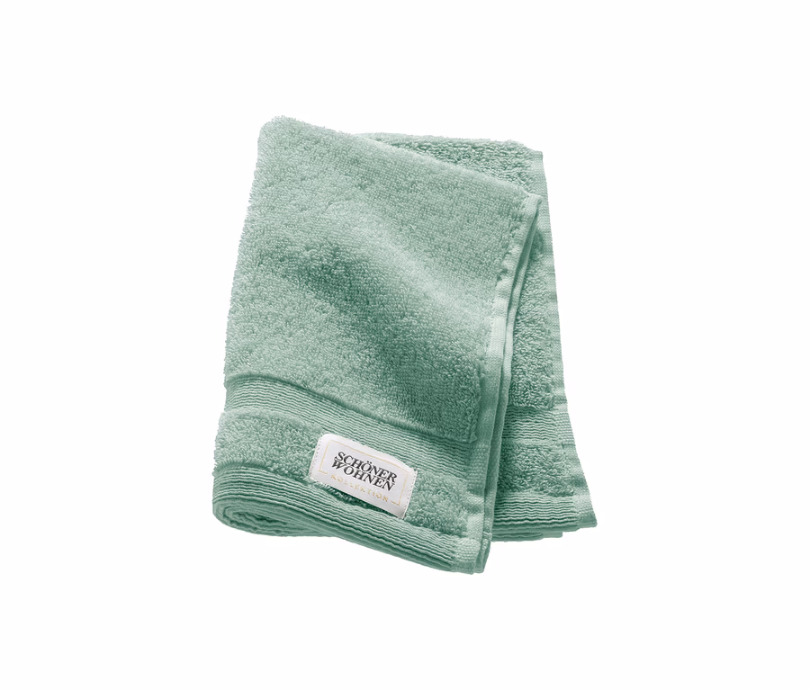 Ein gefaltetes salbeigrünes Gästehandtuch der SCHÖNER WOHNEN-Kollektion „Cuddly“.