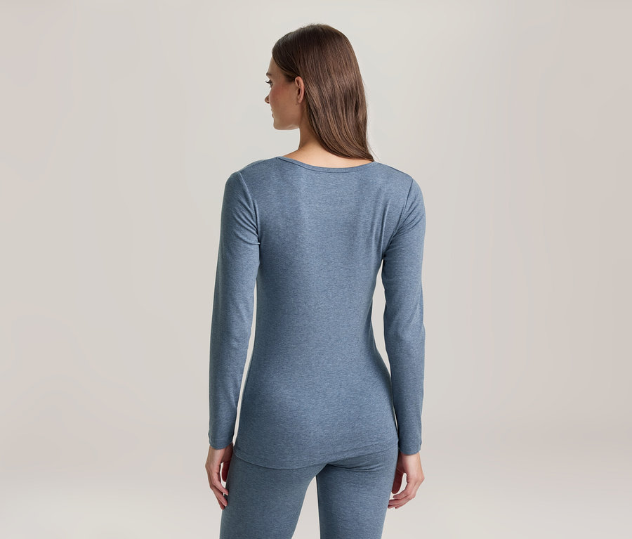 Frau von hinten in blauem Langarmshirt und passenden Leggings, blickt nach links.