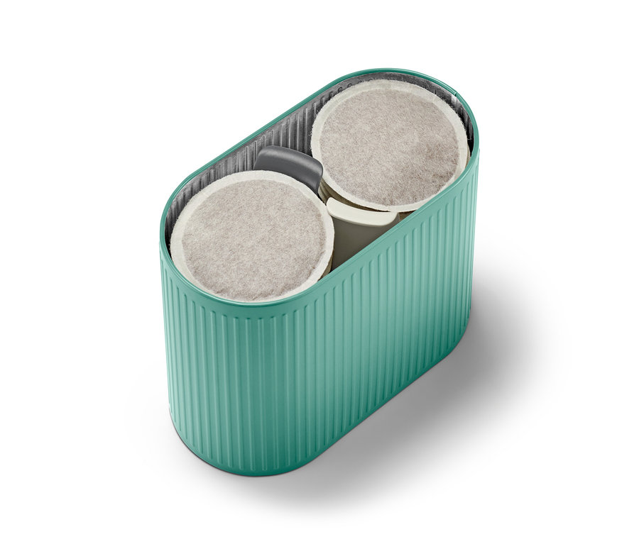 Eine türkise Paddose gefüllt mit Kaffeepads.