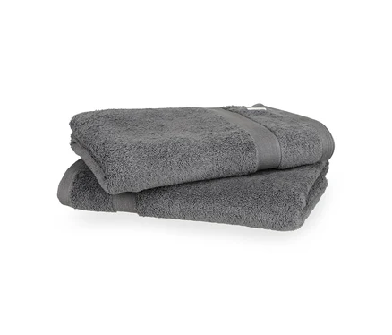 Zwei anthrazitfarbene Badetücher der SCHÖNER WOHNEN-Kollektion »Cuddly«, gefaltet und übereinander gestapelt.