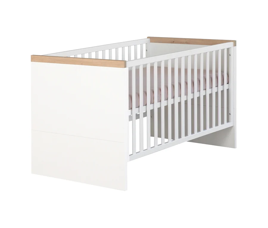 Weißes Babybett mit hellen Holzleisten oben. Eine Seite ist geschlossen, die andere hat vertikale Gitterstäbe. Ein hellrosa Spannbetttuch ist sichtbar.