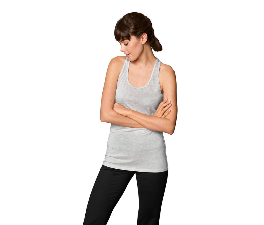 Frau mit verschränkten Armen trägt ein 2-in-1-Sportshirt und eine schwarze Hose.