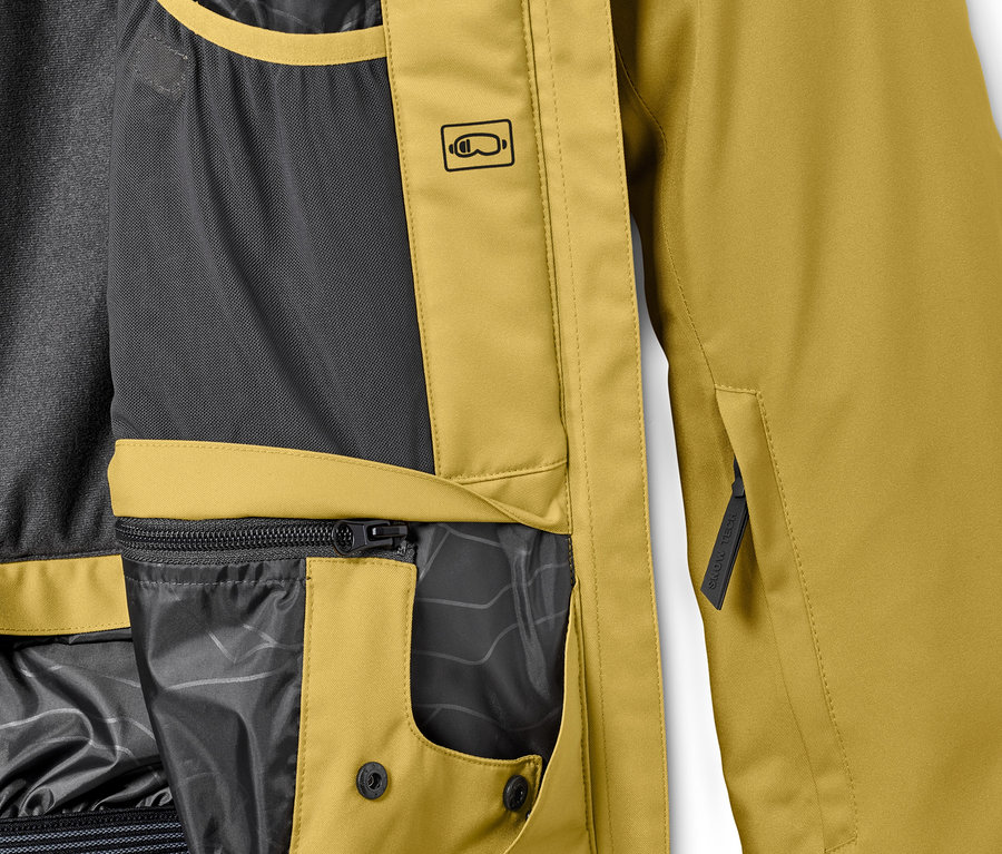 Detailansicht einer senfgelben Skijacke mit Taschen und schwarzem Innenfutter.