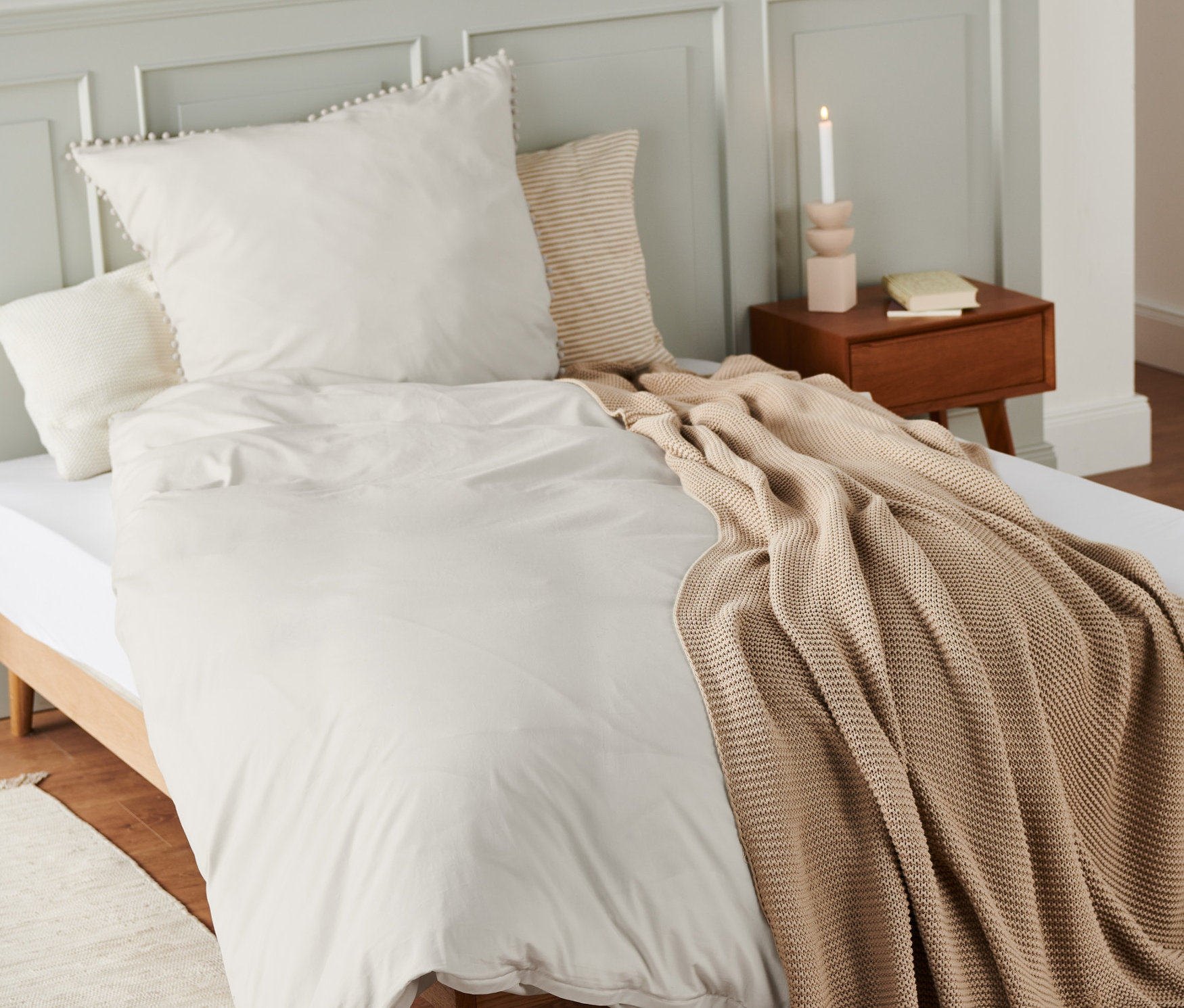 Beige Premium-Baumwoll-Bettwäsche in Normalgröße und Übergröße auf einem Bett.