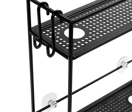 Schwarzes hängendes Duschregal mit zwei Ablagen, das mit transparenten Saugnäpfen an einer weißen Wand befestigt ist.