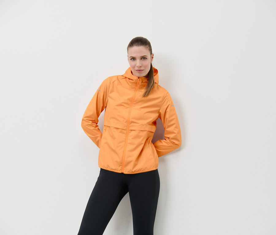 Frau posiert in Windprotection-Laufjacke, neonorange.