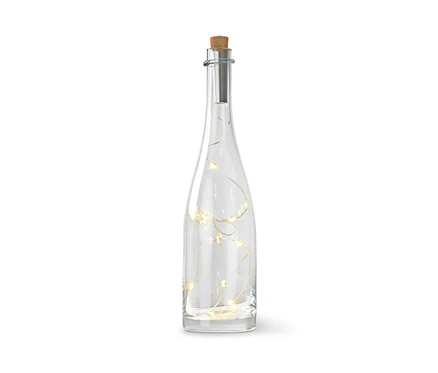 Eine klare Glasflasche mit Korkverschluss und Lichterkette im Inneren.