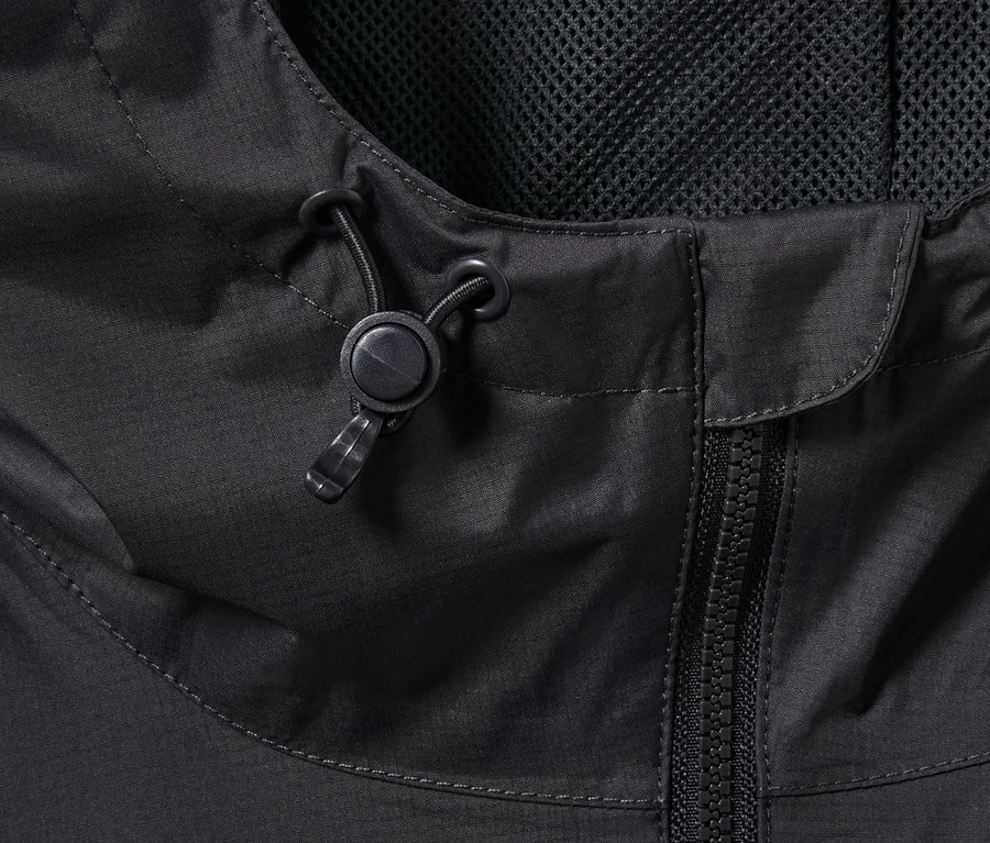 Detailaufnahme einer schwarzen Regenjacke mit Reißverschluss und Kapuzenkordel.