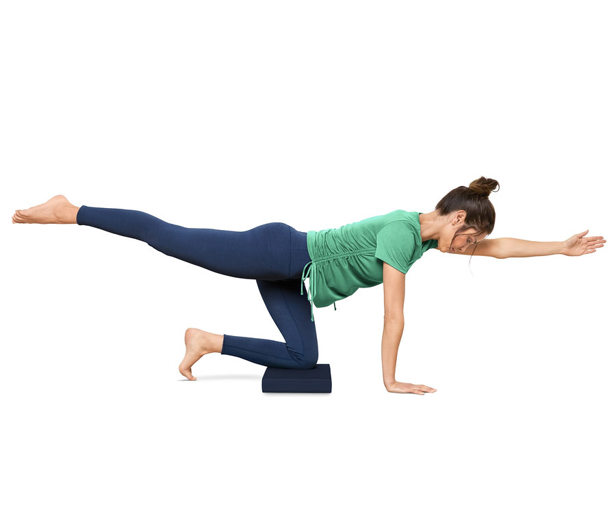 Frau macht Übungen auf einem Balance-Pad.