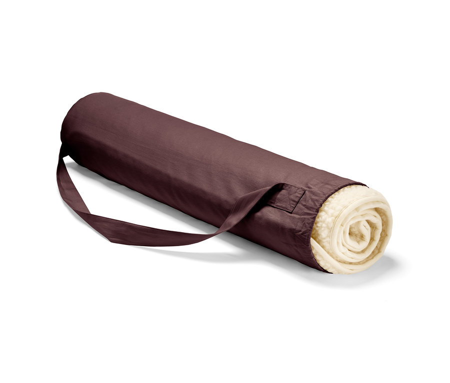 Eine zusammengerollte Schurwoll-Yogamatte in einer bordeauxfarbenen Hülle mit Riemen.