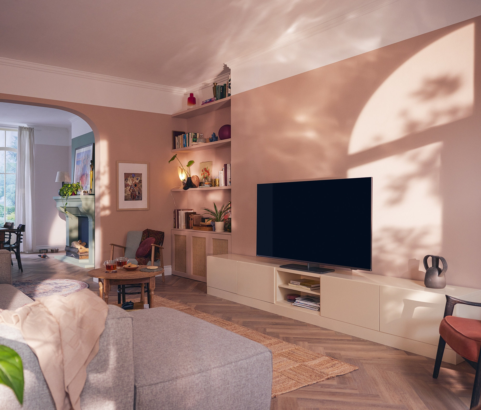 Wohnzimmer mit Philips 4K UHD Ambilight TV mit Google TV der One Serie.