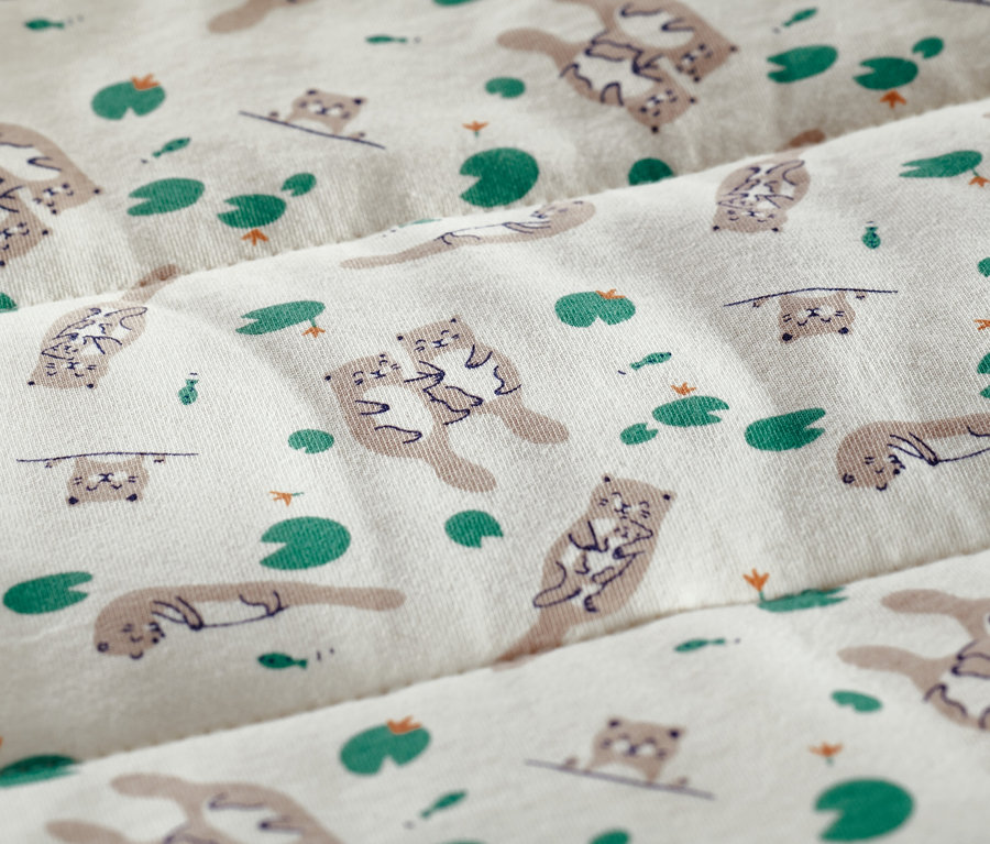 Stoff mit Otter- und Seerosenmuster.