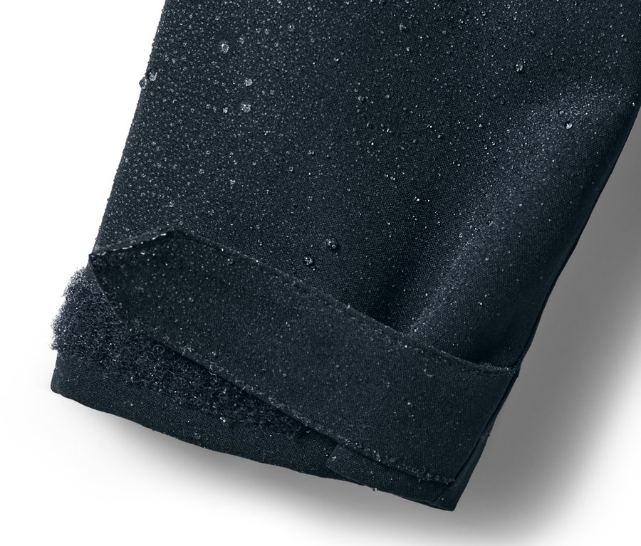 Detailansicht eines Kinder-Regenparka-Ärmels mit Wassertropfen.