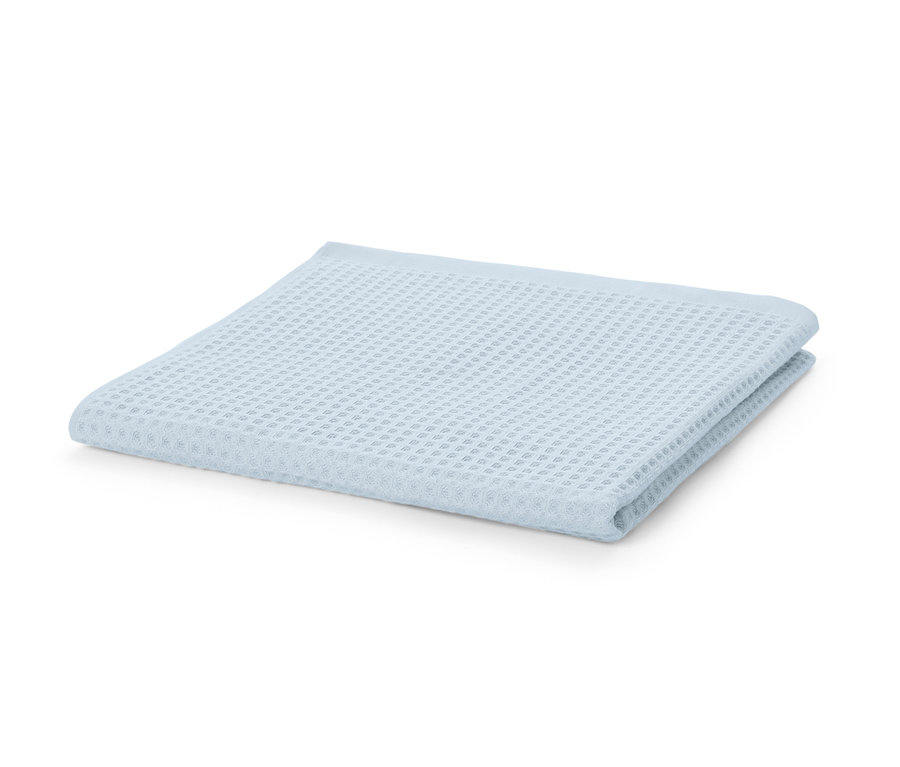 Ein blaues Premium-Waffelpiqué-Badetuch liegt gefaltet auf einem weißen Hintergrund.